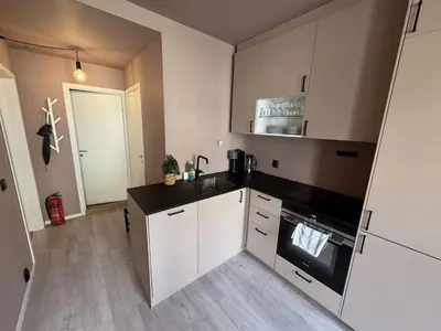 a kitchen with white cabinets and a black counter top at Modern and central apartment in Trondheim in Trondheim