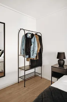 a clothes rack in a bedroom next to a bed at Central apartment building in Bergen