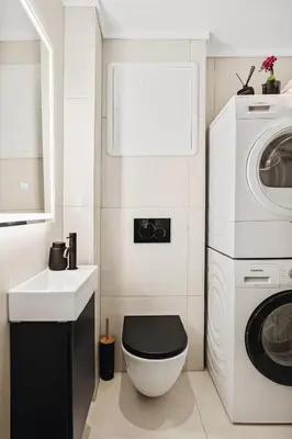 a bathroom with a toilet and a sink and a washing machine at Central apartment building in Bergen