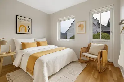 a white bedroom with a large bed and a chair at Cozy Apartment near City Centre in Bergen