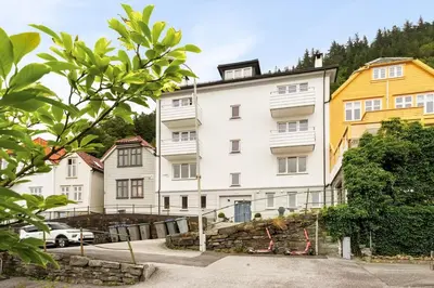 a white building with a yellow house at Appartment Bergen, Skansen in Bergen