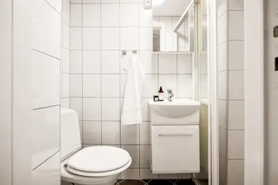 a white bathroom with a toilet and a sink at Appartment Bergen, Skansen in Bergen