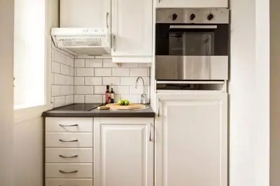 a white kitchen with white cabinets and a sink at Appartment Bergen, Skansen in Bergen