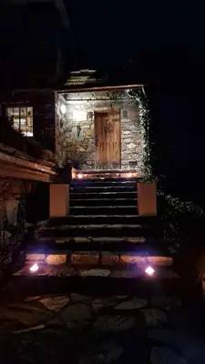 a stone building with a wooden door and stairs at night at Haven Fortress in Lii
