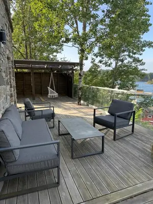 a deck with chairs and a couch and a swing at Haven Fortress in Lii