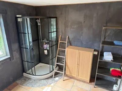 a shower in a room with a ladder and a shelf at Haven Fortress in Lii
