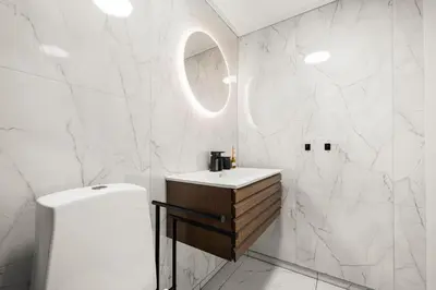 a white bathroom with a sink and a mirror at City Center, Light & Modern Apartment in Bergen