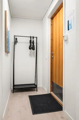 a hallway with a door and a black rug at City Center, Light & Modern Apartment in Bergen