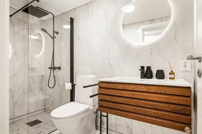a bathroom with a shower and a toilet and a sink at City Center, Light & Modern Apartment in Bergen