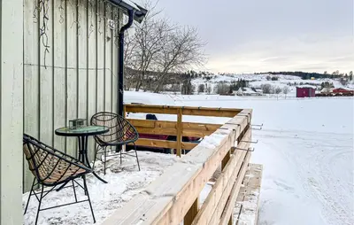 a porch with two chairs and a table in the snow at Cozy Home In Sparbu With Wifi in Sparbu