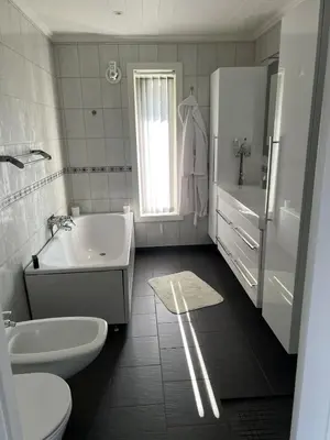 a white bathroom with a sink and a tub and a toilet at Large house by the sea in Bergen