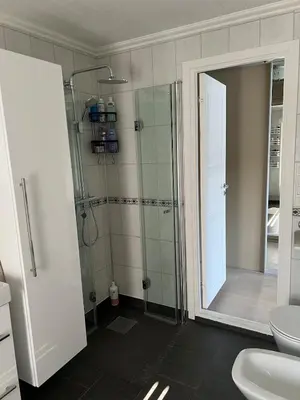 a bathroom with a shower and a toilet and a sink at Large house by the sea in Bergen