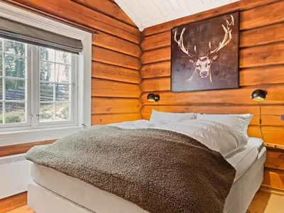 a bedroom with a bed with a deer head on the wall at Exclusive cottage Jacuzzi View Ski in out in Aurdal
