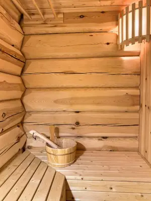a wooden interior of a sauna with a basket at Exclusive cottage Jacuzzi View Ski in out in Aurdal