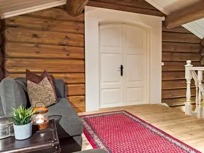 a living room with a white door and wooden walls at Exclusive cottage Jacuzzi View Ski in out in Aurdal