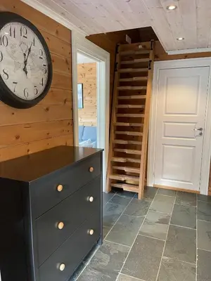 a room with a clock on the wall and a dresser at Velkommen til topp leilighet på Strandafjellet 2 soverom og hems in Stranda