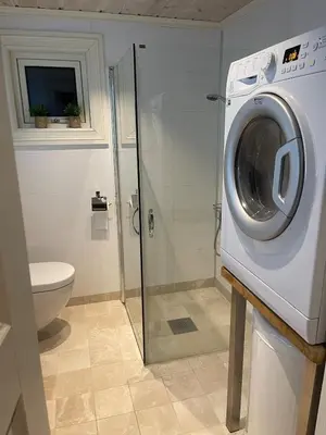 a bathroom with a washing machine and a toilet at Velkommen til topp leilighet på Strandafjellet 2 soverom og hems in Stranda