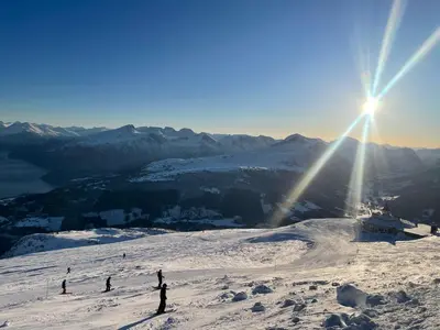 a group of people skiing down a snow covered slope at Velkommen til topp leilighet på Strandafjellet 2 soverom og hems in Stranda
