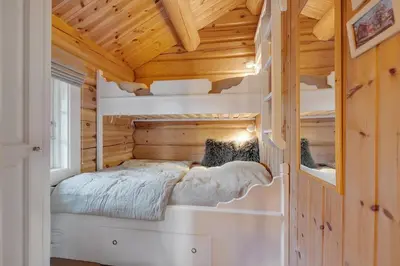 a bedroom in a log cabin with a bed in it at Log cabin in Valdres Fireplace Sauna 1000 m above sea level in Aurdal