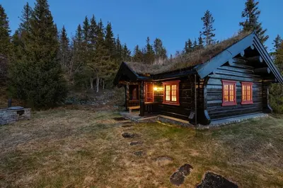 a small log cabin with a grass roof at Log cabin in Valdres Fireplace Sauna 1000 m above sea level in Aurdal