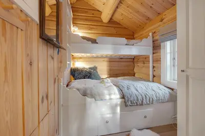 a bed in a room with a wooden ceiling at Log cabin in Valdres Fireplace Sauna 1000 m above sea level in Aurdal