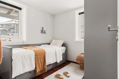 a small bedroom with a bed and a window at Bright and cozy 2-bedroom apartment in Bergen