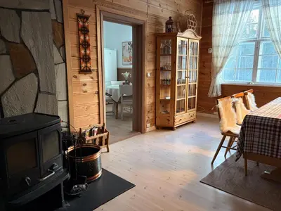 a living room with a stove and a dining room at Valhalla Hytte in Oppdal