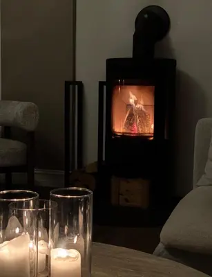 a living room with a fireplace with candles on a table at Central Jugend apartment in Ålesund in Ålesund