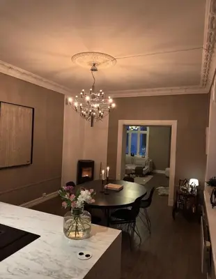 a kitchen and dining room with a table and a chandelier at Central Jugend apartment in Ålesund in Ålesund