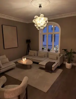 a living room with a couch and a chandelier at Central Jugend apartment in Ålesund in Ålesund