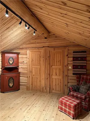 a living room with a tv in a wooden room at Norsk laftehytte Filefjell I 123 kvm I10 sengeplasser I 2 stuer in Borgund