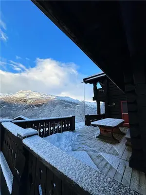 a balcony with a table and snow on a mountain at Norsk laftehytte Filefjell I 123 kvm I10 sengeplasser I 2 stuer in Borgund