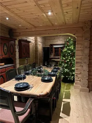 a large wooden table with a christmas tree in a room at Norsk laftehytte Filefjell I 123 kvm I10 sengeplasser I 2 stuer in Borgund