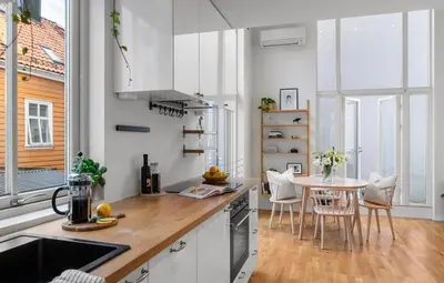 a kitchen with white cabinets and a table with chairs at Modern and airy apartment in Bergen city center in Bergen