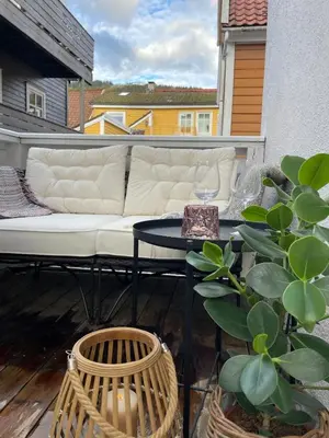 a couch and a table on a balcony at Modern and airy apartment in Bergen city center in Bergen