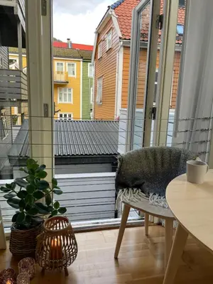 a balcony with a couch and a table and a window at Modern and airy apartment in Bergen city center in Bergen