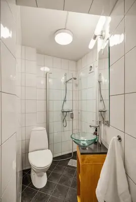 a bathroom with a toilet and a glass sink at Central and cozy apartment in Bergen City Center in Bergen