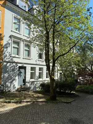 a white house with a tree in front of it at Central and cozy apartment in Bergen City Center in Bergen