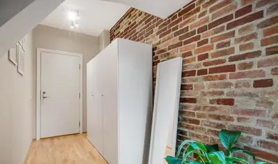 a room with a brick wall and two white doors at Central and cozy apartment in Bergen City Center in Bergen