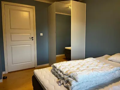 a bedroom with a bed and a white door at Apartment Stedjeåsen 70 in Sogndal