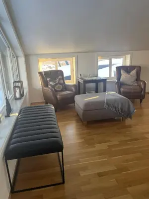 a living room with a bed and a couch and chairs at Romslig toppleilighet 134 kvm med balkong perfekt for firma og grupper in Beitostøl