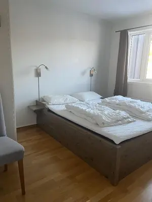 a large bed in a bedroom with a window at Romslig toppleilighet 134 kvm med balkong perfekt for firma og grupper in Beitostøl