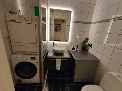 a bathroom with a washing machine and a sink at Modern apartment in central Bergen in Bergen