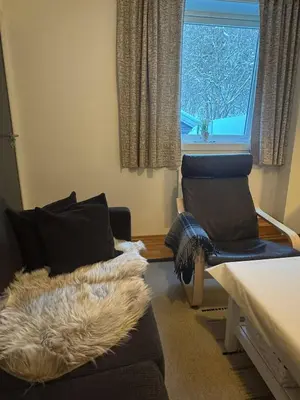 a living room with a couch and a window at Oppheim Mountain Resort - Pool, Sauna & Lake! in Vossevangen