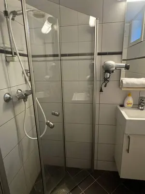 a shower with a glass door in a bathroom at Oppheim Mountain Resort - Pool, Sauna & Lake! in Vossevangen