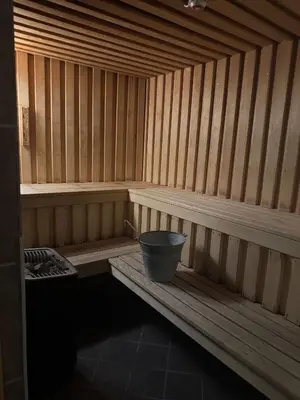 a small wooden sauna with a bucket in it at Oppheim Mountain Resort - Pool, Sauna & Lake! in Vossevangen