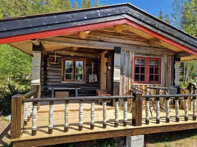 a log cabin with a porch and a deck at Smia cabin , A Unique Rustic Hideaway in Lii