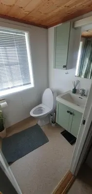 a bathroom with a toilet and a sink and a window at Sunset Cabin in Ålesund