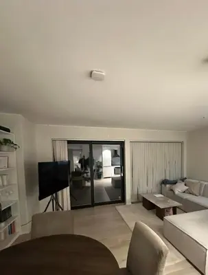 a living room with a couch and a tv at Stor og moderne leilighet ved råstølen bybanestopp in Bergen