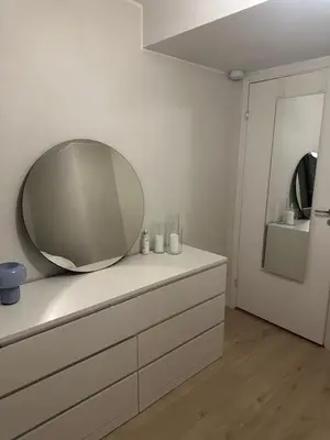 a bathroom with a mirror on top of a dresser at Stor og moderne leilighet ved råstølen bybanestopp in Bergen